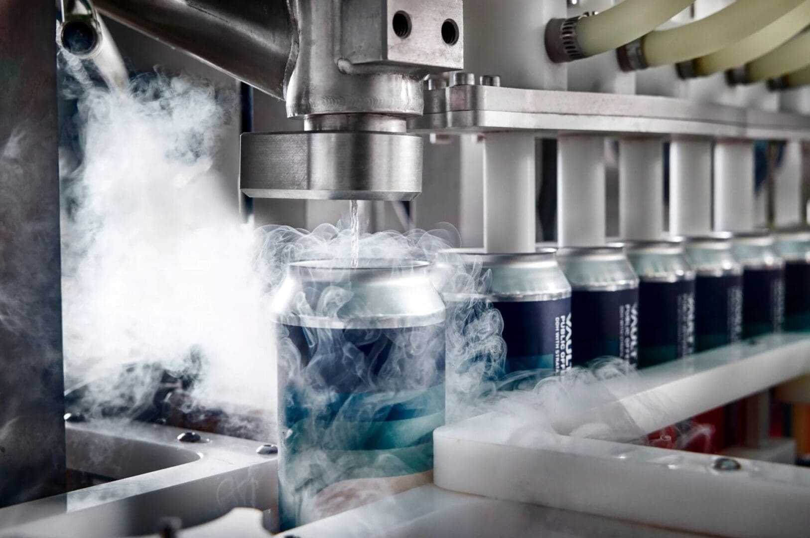 A machine is pouring soda into cans.